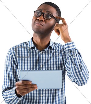 Young businessman thinking and holding tablet