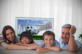 Family smiling at the camera with world cup showing on television