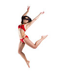 Fit girl in red bikini smiling and leaping