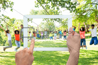 Composite image of hand holding tablet pc