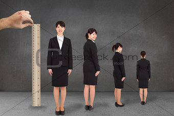 Composite image of hand measuring businesswoman with ruler