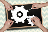 Composite image of multiple hands drawing cogs with chalk