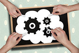 Composite image of multiple hands drawing cogs with chalk