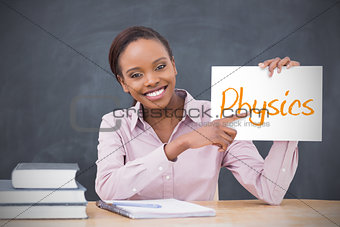 Happy teacher holding page showing physics