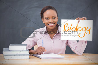 Happy teacher holding page showing biology
