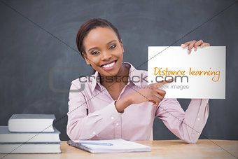 Happy teacher holding page showing distance learning