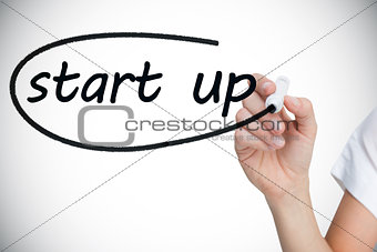 Businesswoman writing the words start up