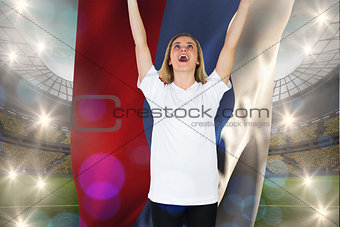 Composite image of cheering football fan in white holding russia flag