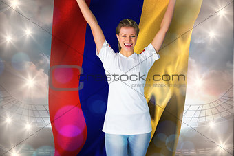Composite image of pretty football fan in white cheering holding colombia flag