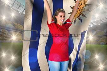 Composite image of cheering football fan in red holding uruguay flag