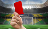 Composite image of hand holding up red card