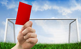 Composite image of hand holding up red card