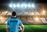 Composite image of argentina football player holding ball
