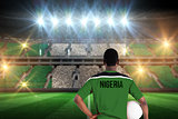Composite image of nigeria football player holding ball