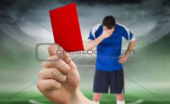 Composite image of hand holding up red card to player