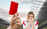 Composite image of hand holding up red card to fan