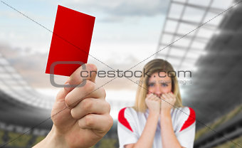 Composite image of hand holding up red card to fan