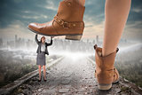 Composite image of cowboy boots stepping on businesswoman