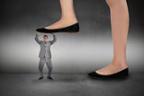 Composite image of businesswoman stepping on tiny businessman