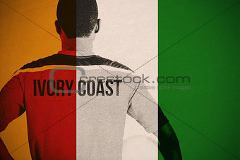 Composite image of ivory coast football player holding ball