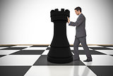 Composite image of businessman pushing chess piece