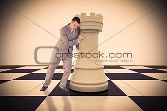Composite image of portrait of a handsome businessman pushing chess piece