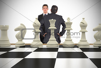 Composite image of businessmen and chess pieces