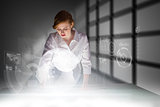 Composite image of redhead businesswoman using interactive desk