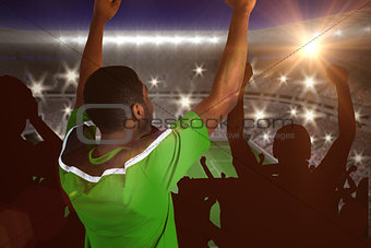 Composite image of cheering football fan in green jersey