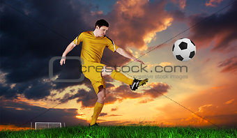 Composite image of football player in yellow kicking