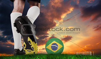 Composite image of football boot kicking brazil ball