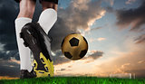 Composite image of football boot kicking gold ball