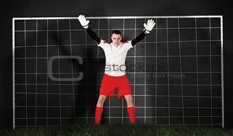 Composite image of goalkeeper in red and white ready to catch