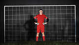 Composite image of goalkeeper in red looking at camera