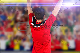 Composite image of excited football player cheering