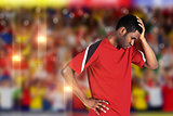 Composite image of disappointed football fan looking down