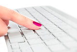 Female finger touching keyboard.