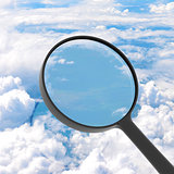 Magnifying glass looking clouds in background