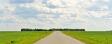 Green grass, road and clouds