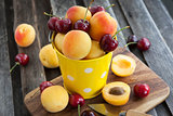 Fresh apricot and cherry in a bucket