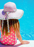 Young girl sat by the pool 