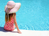 Young girl sat by the pool 