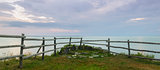 Panorama of a wooden fence on ocean shore in the morning