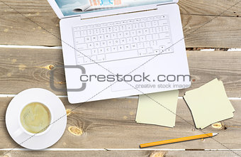 Laptop and coffee cup on old wooden boards