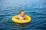 Little boy in water on rubber ring