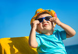 Boy kid in sun glasses and hat on beach