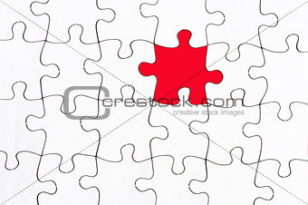 blank white jigsaw with one red piece