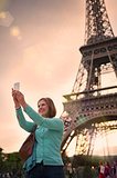 mature woman taking a selfie with the eiffel tower paris