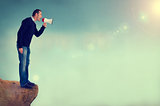 man with megaphone shouting from cliff edge