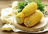 fresh boiled cob corn on a wooden plate